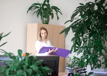 Femme dans son bureau lisant le contenu d'un classeur