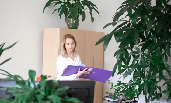 Femme dans son bureau lisant le contenu d'un classeur